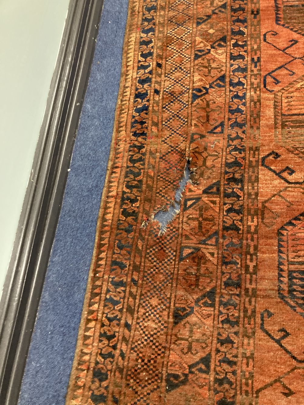 An antique Bokhara burgundy ground carpet, 400 x 280cm